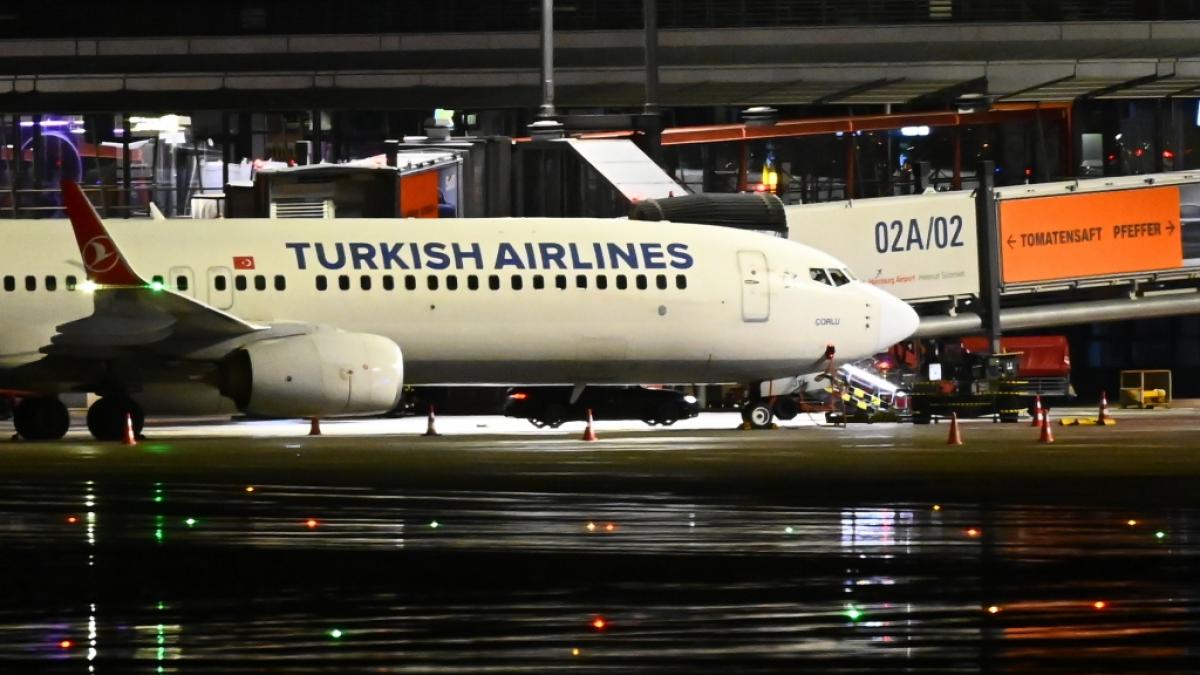 Ein dunkles Auto steht am Flughafen unter einem Flieger auf dem Hamburger Flughafen. Das Flugzeug der Turkish Airlines, unter dem der Geiselnehmer sein Auto abgestellt hatte, wurde ger&auml;umt. (Foto)