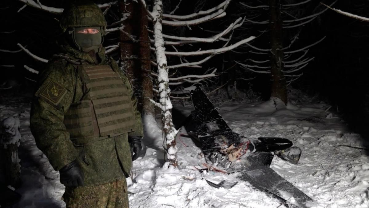 Ein Mann in Tarnkleidung steht neben einer angeblich abgeschossenen Drohne, die an einem vermeintlichen Angriff auf eine Residenz von Russlands Pr&auml;sident Wladimir Putin beteiligt war. (Foto)