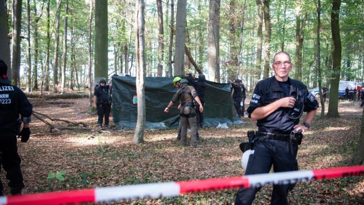 Rettungskräfte im Hambacher Forst kümmern sich um einen Mann, der 15 Meter tief durch eine Hängebrücke gebrochen ist.