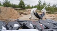 Ermittler tragen den Leichensack mit den sterblichen Überresten eines ukrainischen Soldaten bei einer Begräbnisstätte in Lyman. Dort hatten Kreml-Kämpfer offenbar auch wahllos Zivilisten getötet.