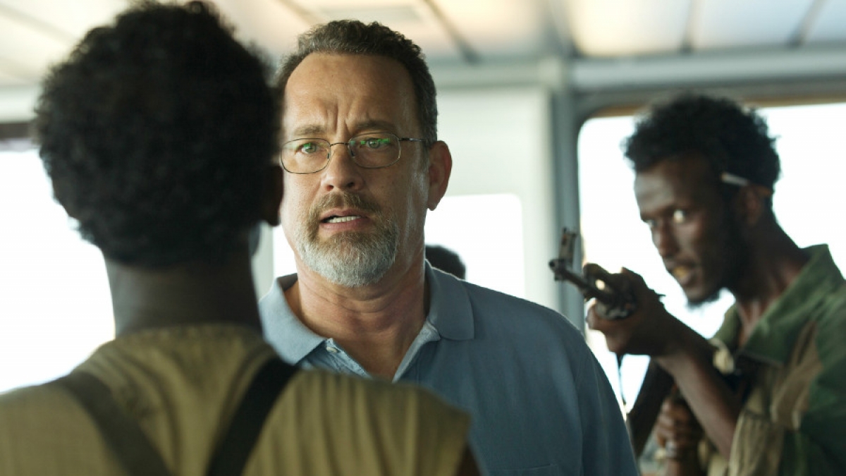 Captain Richard Phillips (Tom Hanks) wird von den Piraten Muse (Barkhad Abdi, l.) und Elmi (Mahat M. Ali, r.) bedroht. (Foto)