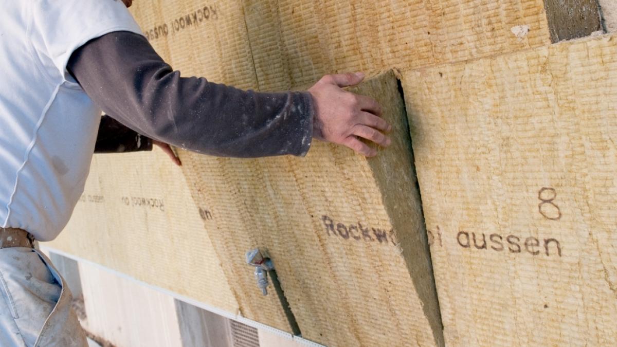 Auf einer Baustelle wird die Fassade eines Wohnhauses ged&auml;mmt (Symbolbild). (Foto)
