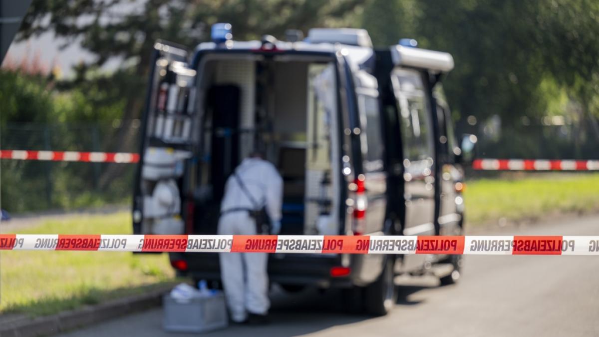 Ein Mitarbeiter der Spurensicherung ist vor einem Einsatzfahrzeug zu sehen. Ein Mann wurde in Erfurt erschossen. Der Gro&szlig;einsatz der Polizei l&auml;uft. (Foto)