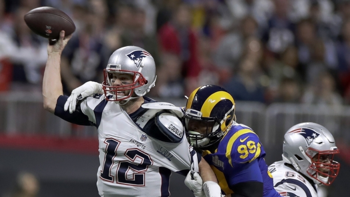 NFL-Profiliga, 53. Super Bowl, Mercedes-Benz Stadium, Los Angeles Rams - New England Patriots. Tom Brady (l) von den Patriots wirft w&auml;hrend Aaron Donald von den Los Angeles Rams versucht ihn daran zu hindern. (Foto)