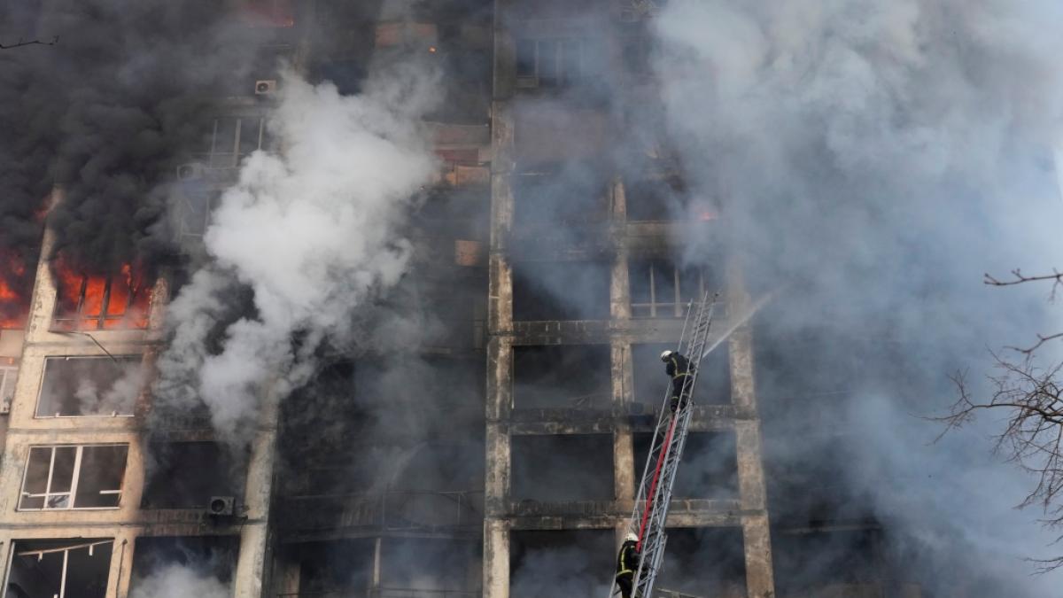 Feuerwehrleute l&ouml;schen die Br&auml;nde in einem durch Beschuss besch&auml;digten Wohngeb&auml;ude. (Foto)