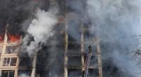 Feuerwehrleute löschen die Brände in einem durch Beschuss beschädigten Wohngebäude.