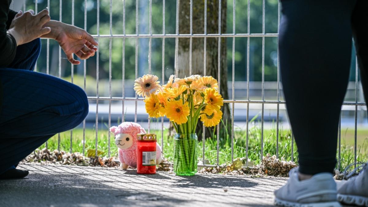 Eine Frau legt in Schorndorf (Baden-W&uuml;rttemberg) Blumen nieder, nachdem ein lebloses Kind in einem Auto gefunden wurde. (Foto)