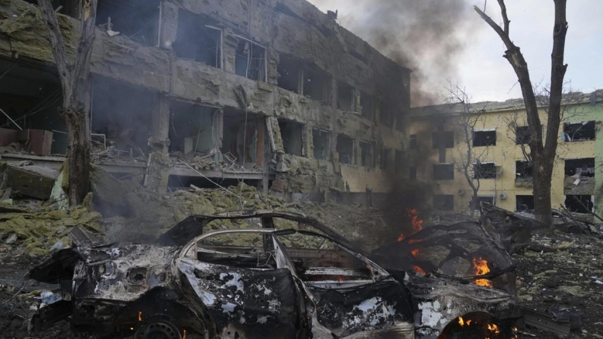 Ein Auto brennt neben einer durch einen Angriff besch&auml;digten Geburtsklinik in Mariupol. (Foto)