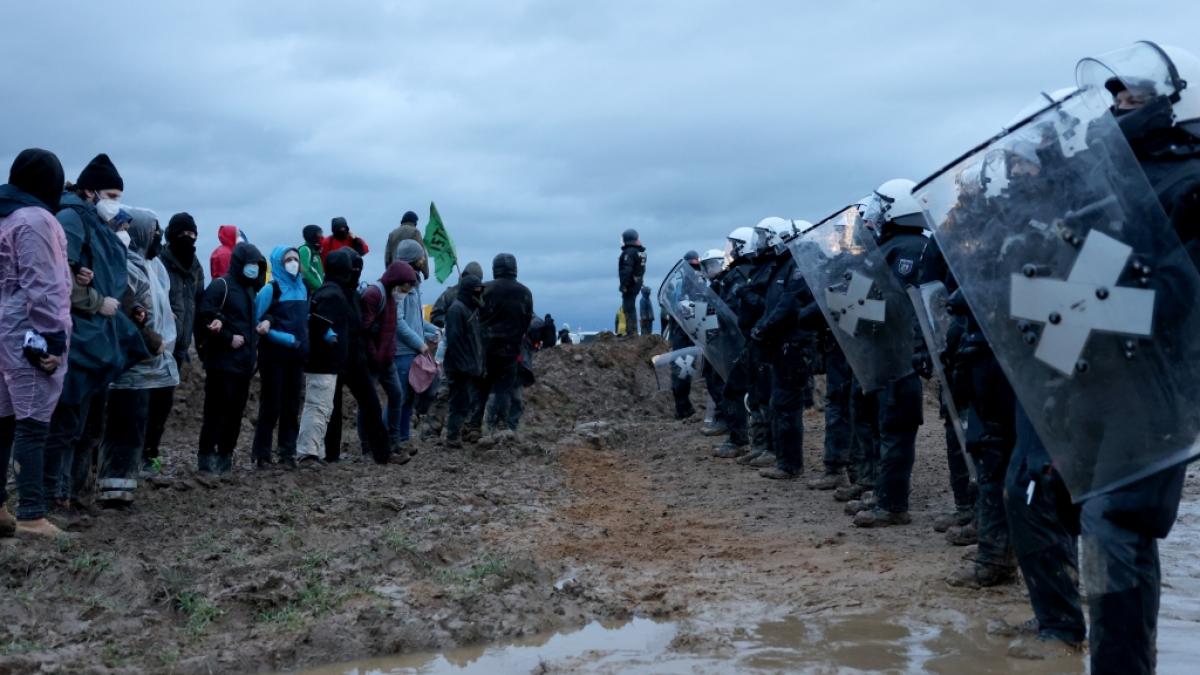 Polizisten und Demonstranten stehen sich bei der Demonstration von Klimaaktivisten am Rande des Braunkohletagebaus bei L&uuml;tzerath gegen&uuml;ber. (Foto)