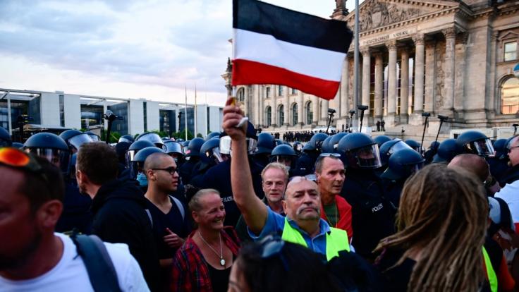 Berlin: Teilnehmer einer Kundgebung gegen die Corona-Maßnahmen stehen vor dem Reichstag.