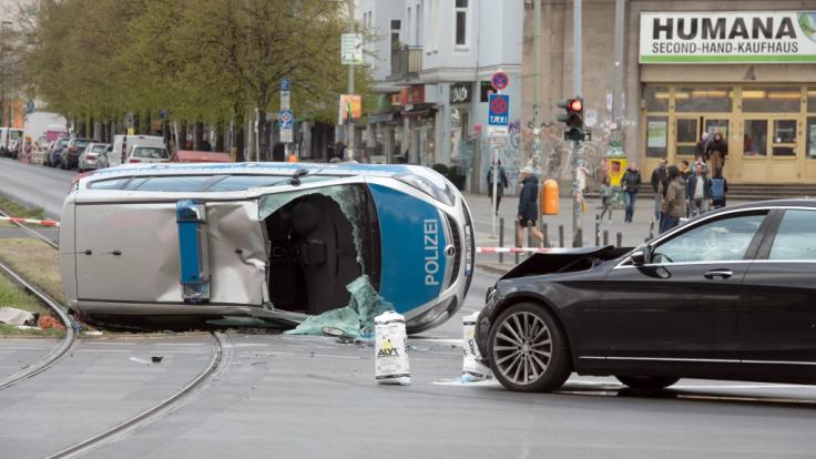 Der umgekippte Streifenwagen liegt nach einem Zusammenstoß mit einem Pkw auf einem Grünstreifen am Frankfurter Tor.