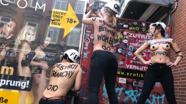 Femen-Aktivistinnen reißen einen Sichtschutz in Hamburgs Rotlichtviertel ein.