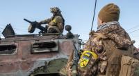 Ukrainische Soldaten inspizieren ein beschädigtes Militärfahrzeug nach Kämpfen in Charkiw.