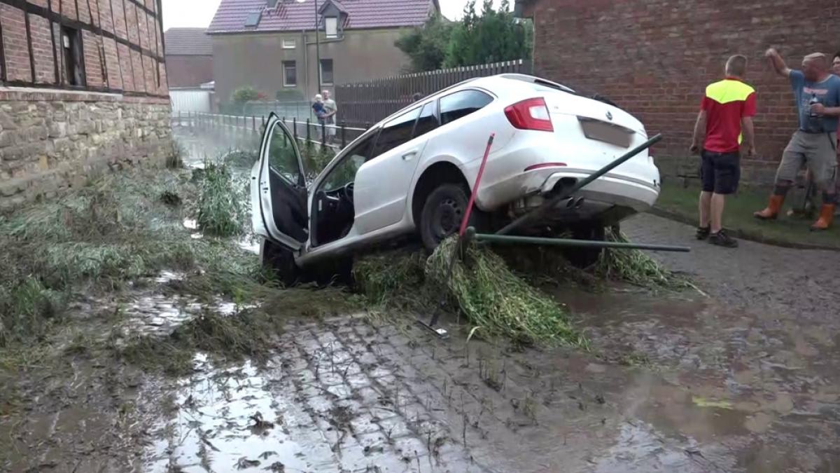 Ein Auto, das von den Wassermassen mitgerissen wurde, h&auml;ngt in einem Bachbett in Beckendorf nahe Oschersleben nach einem heftigen Unwetter mit Starkregen und Hagel. (Foto)