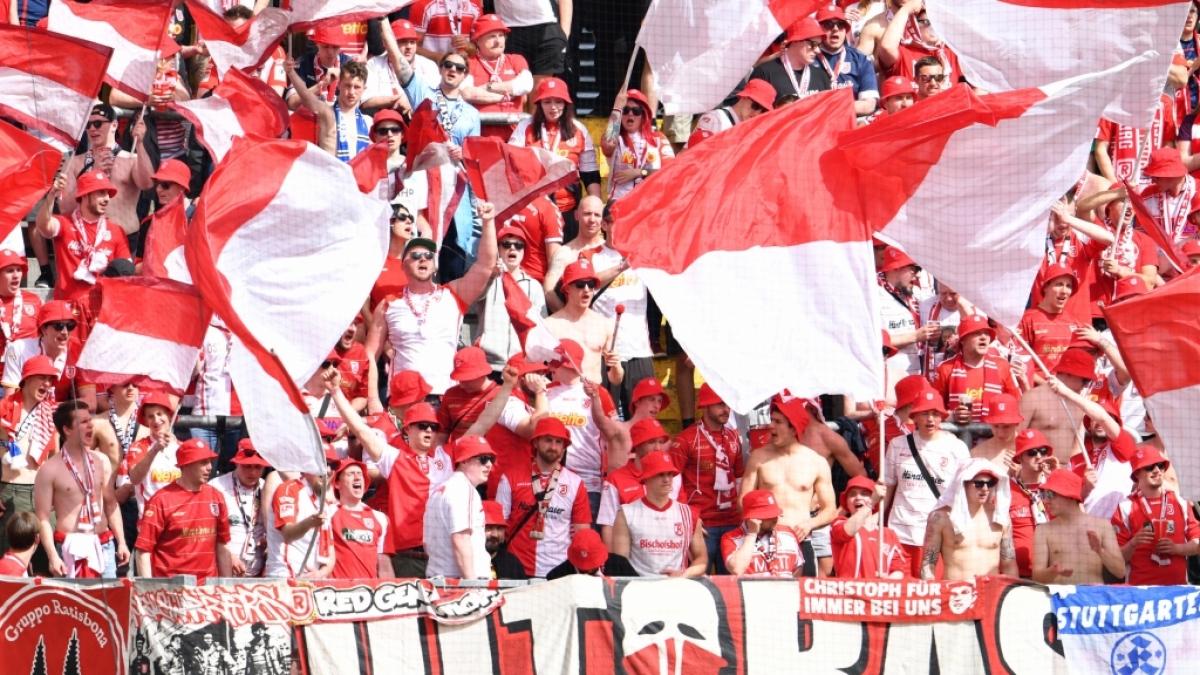 Mit wehenden Fahnen feuern die Fans vom SSV Jahn Regensburg ihren Verein an. (Symbolbild) (Foto)