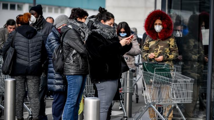 In Italien drängen sich Hunderte Menschen vor einem Supermarkt. Nach dem Tod zweier Menschen sind Teile des öffentlichen Lebens in Italien zum Erliegen gekommen.