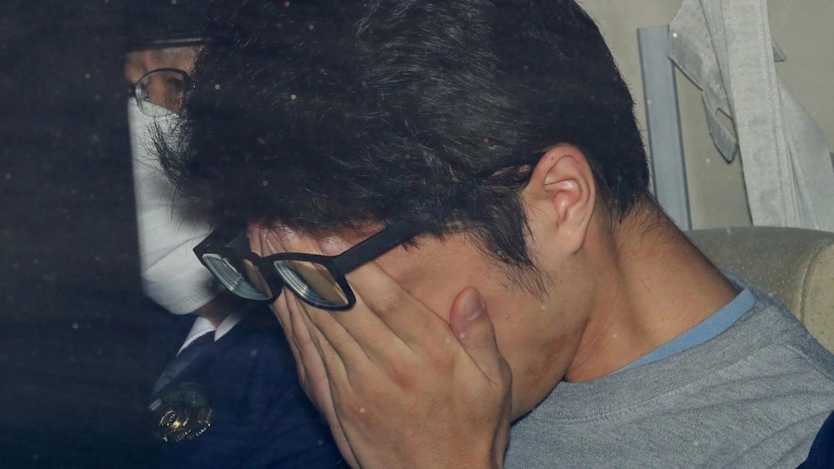 Der in Japan angeklagte und inzwischen verurteilte "Twitter-Killer" h&auml;lt seine H&auml;nde vors Gesicht, als er aus einer Polizeistation gebracht wird. (Foto)