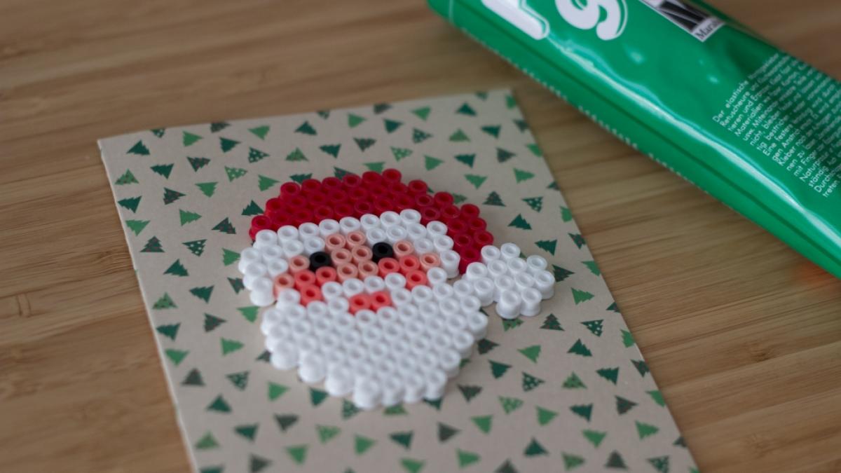 Bastelanleitung f&uuml;r eine Weihnachtskarte mit B&uuml;gelperlen. (Foto)