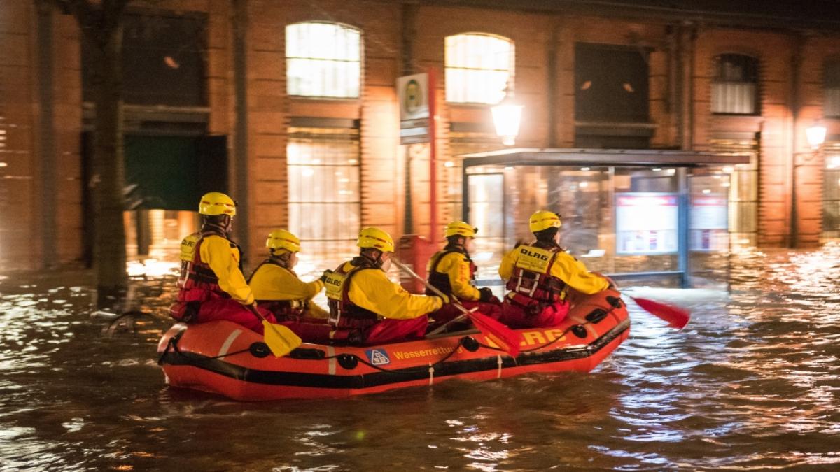 Sturmflut in Hamburg: Mitglieder der DLRG am unter Wasser stehenden Fischmarkt mit der Fischauktionshalle an der Elbe. (Foto)