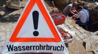 Nach Rohrbruch: Zwei Männer arbeiten an einem defekten Rohr (Archivbild).