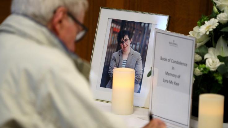 Ein Mann schreibt in ein Kondolenzbuch für Lyra McKee ein.