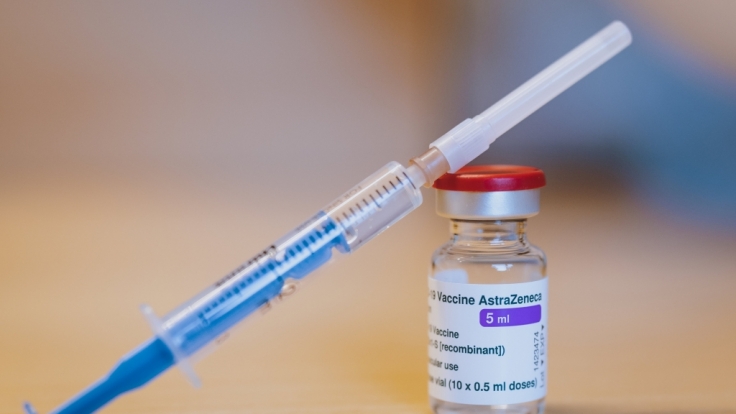 Eine Spritze ist an eine Ampulle mit dem Corona-Impfstoff von AstraZeneca gelehnt.