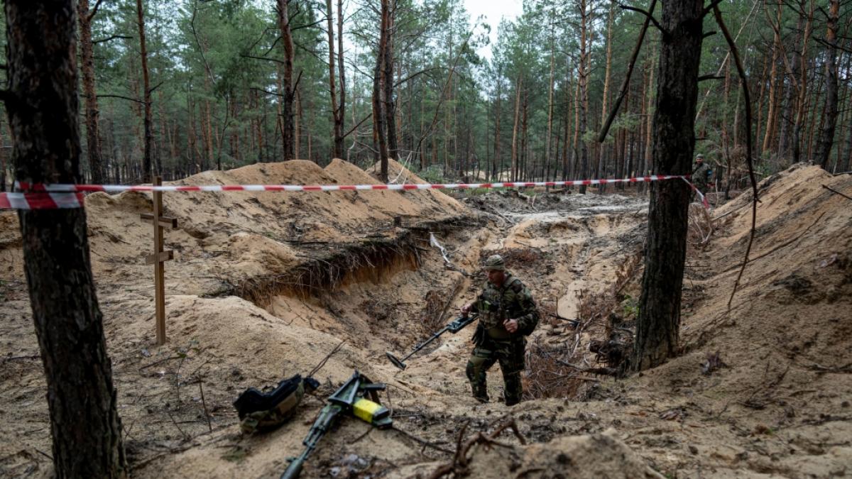 Ein ukrainischer Soldat inspiziert mit einem Metalldetektor ein Massengrab in der k&uuml;rzlich zur&uuml;ckeroberten Stadt Isjum. (Foto)