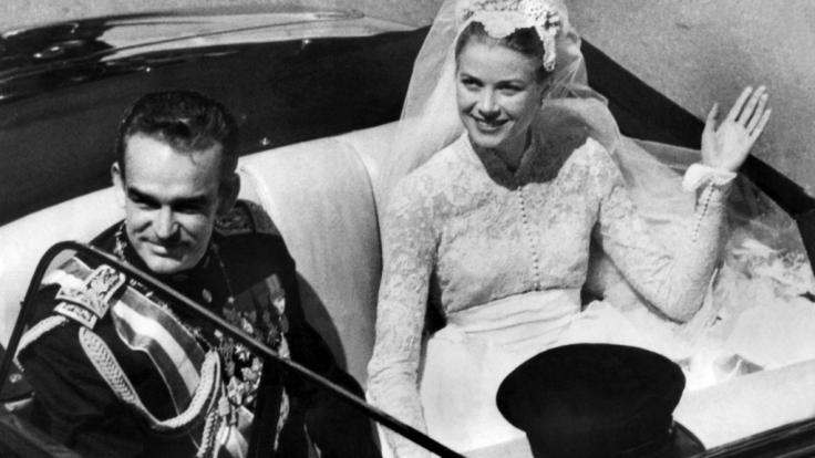 Fürst Rainier III. von Monaco und seine Braut, die US-amerikanische Filmschauspielerin Grace Kelly winken nach ihrer Hochzeit den Schaulustigen zu.