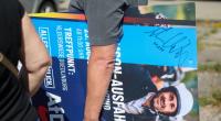 Ein Wähler hat ein signiertes Plakat in der Hand von AfD-Spitzenkandidat Ulrich Siegmund.