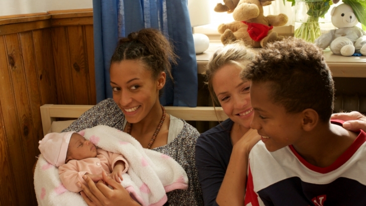 Hebamme Lena (Patricia Aulitzky, Mitte) zögert nicht lange und nimmt Senait (Sabrina Ceesay, links) und ihren Sohn Anbessa (Ruben Felipe, rechts) bei sich auf, die aus Eritrea geflüchtet sind.