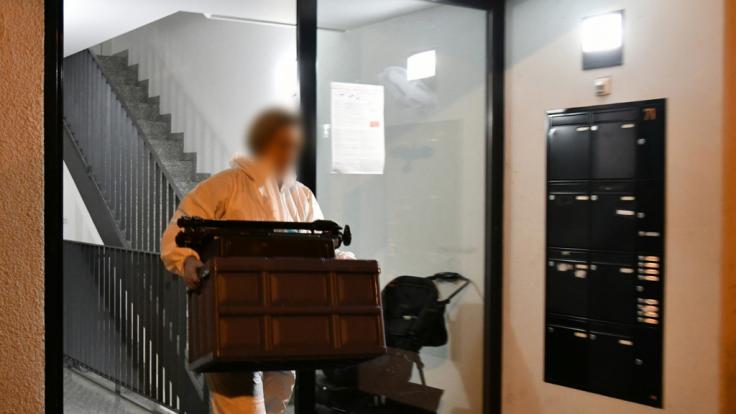 Eine Mitarbeiterin der Spurensicherung trägt einen Kasten aus einem Haus im Stadtteil Eberstadt. In einer Wohnung in Darmstadt waren Leichenteile gefunden worden.