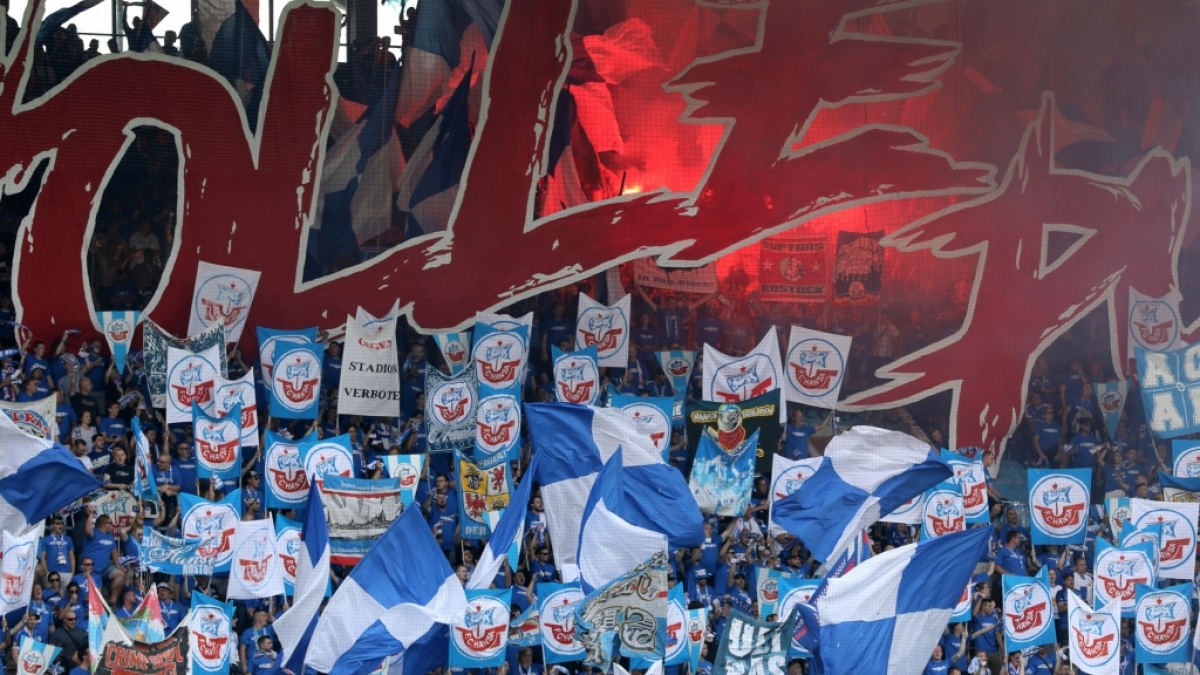 Die blauen Fahnen mit dem roten Schiff wehen &uuml;ber der Fankurve des FC Hansa Rostock. (Symbolbild) (Foto)