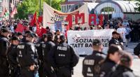 Polizisten stehen neben Teilnehmern während der 