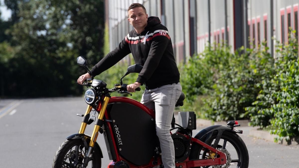 Influencer Aaron Troschke st&uuml;tzt sich auf ein Elektromotorrad. (Foto)