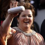 Melissa McCarthy strahlt fröhlich in jede Kamera.