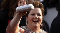 Melissa McCarthy strahlt fröhlich in jede Kamera.