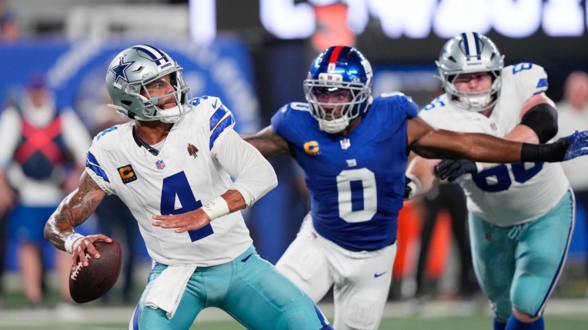 Profiliga NFL, Hauptrunde, New York Giants - Dallas Cowboys. Dak Prescott (4), Quarterback der Dallas Cowboys, sucht nach einem Passziel, w&auml;hrend Brian Burns (0), Linebacker der New York Giants, den Block von TJ Bass (66) von den Cowboys umgeht. (Foto)