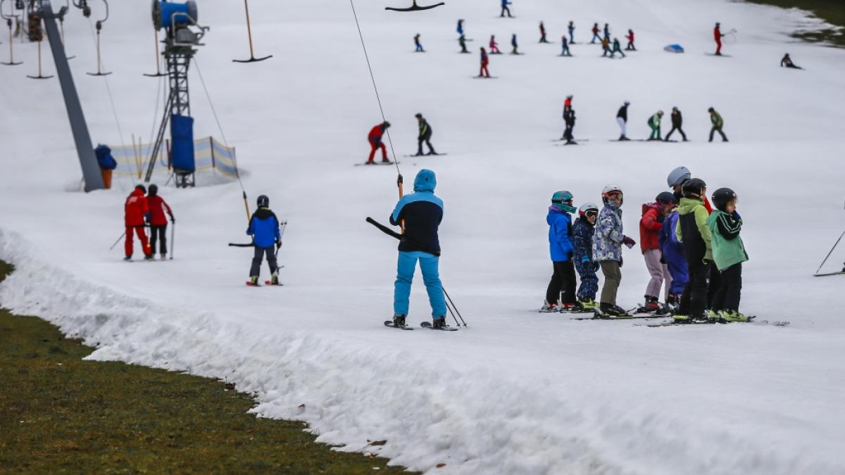 Wintersportler fahren bei Plusgraden auf den Resten einer Skipiste im oberbayerischen Landkreis Traunstein. (Foto)