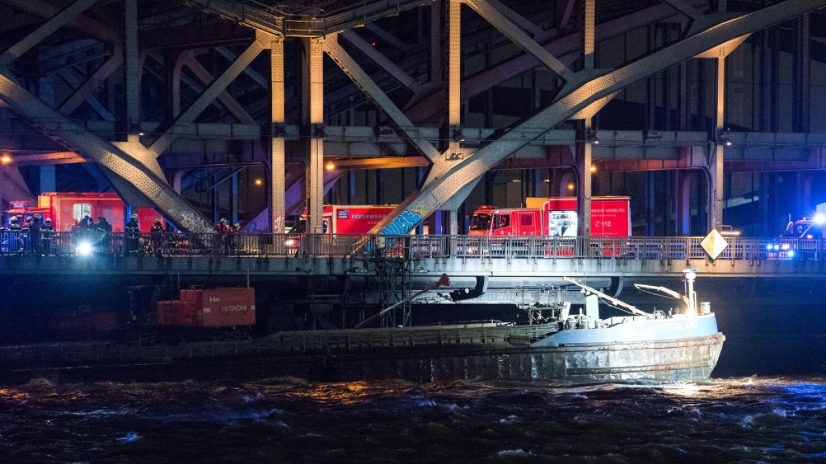 Ein Binnenschiff h&auml;ngt unter der Freihafenelbbr&uuml;cke fest. Beim Durchfahren der Br&uuml;cke im starken Sturm war das Schiff mit dem Steuerhaus an der Br&uuml;cke h&auml;ngengeblieben und hat sich dabei verklemmt. (Foto)
