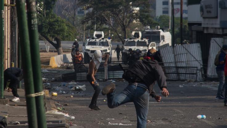 Demonstranten werfen Molotowcocktails in Richtung venezolanischer Sicherheitskräfte.