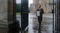 Ein Angestellter hängt an den Toren des Palace of Holyroodhouse in Edinburgh eine Nachricht über den Tod von Königin Elizabeth II. aus.