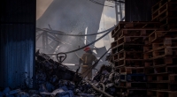 Feuerwehrleute sind in der ukrainischen Hauptstadt damit beschäftigt, einen Brand in einem zerstörten Lager für Haushaltschemikalien zu löschen, das durch einen russischen Raketen- und Drohnenangriff beschädigt wurde.